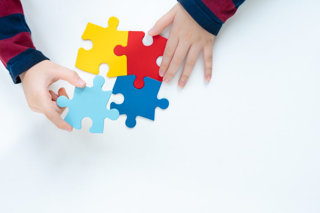 Criança com quebra-cabeças colorido, para falar sobre a relação entre Autismo e epilepsia