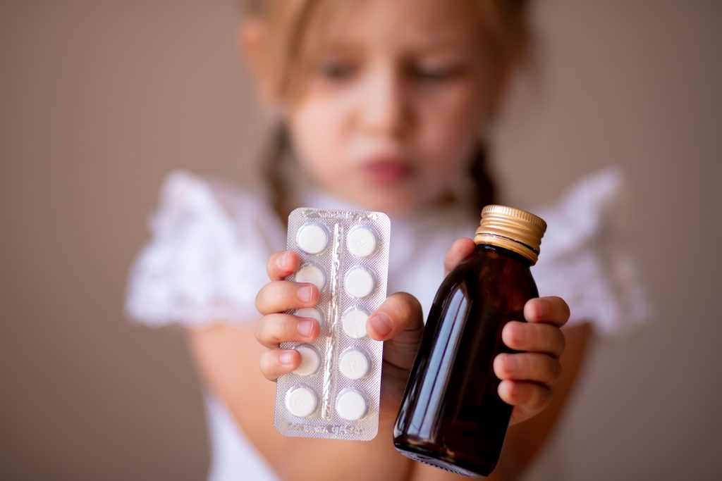 Criança segurando vários Novos medicamentos para epilepsia infantil.