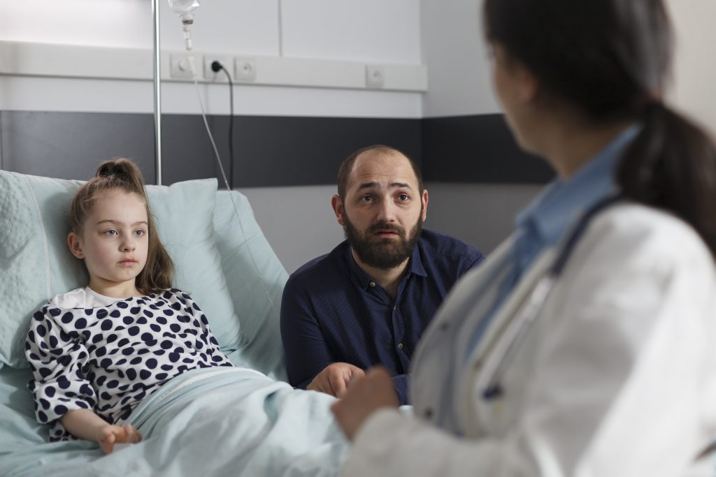Criança numa cama de hospital com Estado de mal epiléptico.