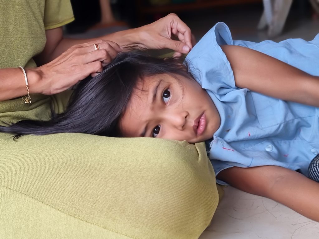 Criança com Epilepsia mioclônica juvenil recebendo carinho.