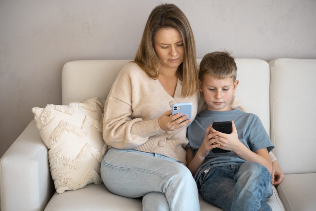 Mãe e filho no sofá, lendo sobre a pesquisa colaborativa