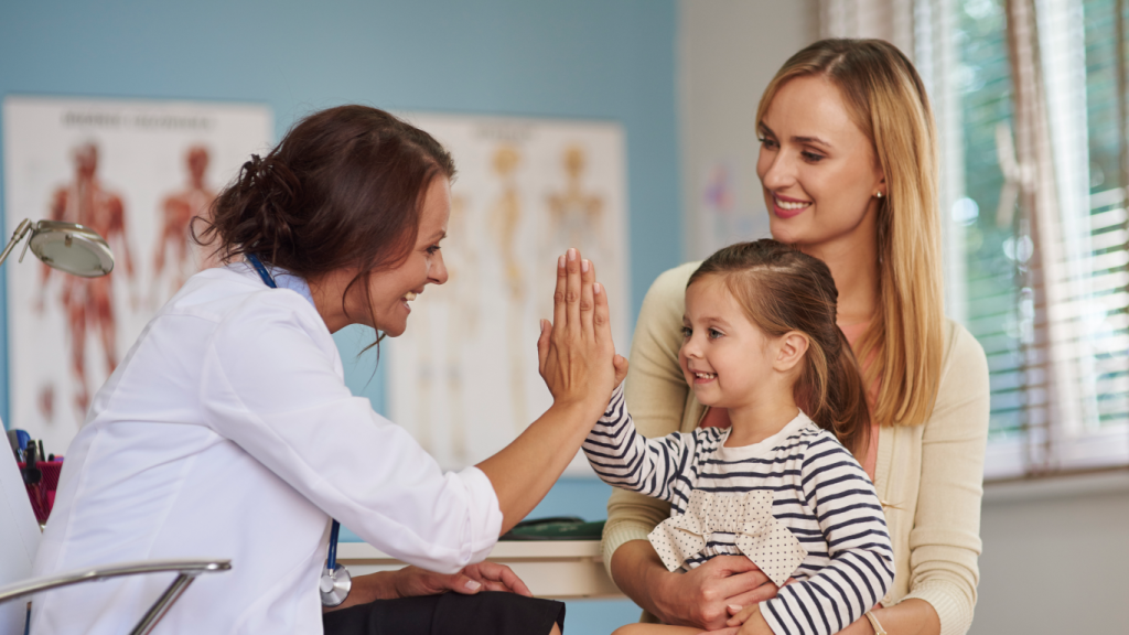 Médica atendendo criança no colo da mãe, para falar sobre epilepsia genética