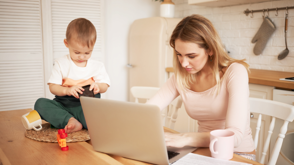 Mulher com o seu filho ao lado, pesquisando no notebook sobre crises epilépticas não convulsivas