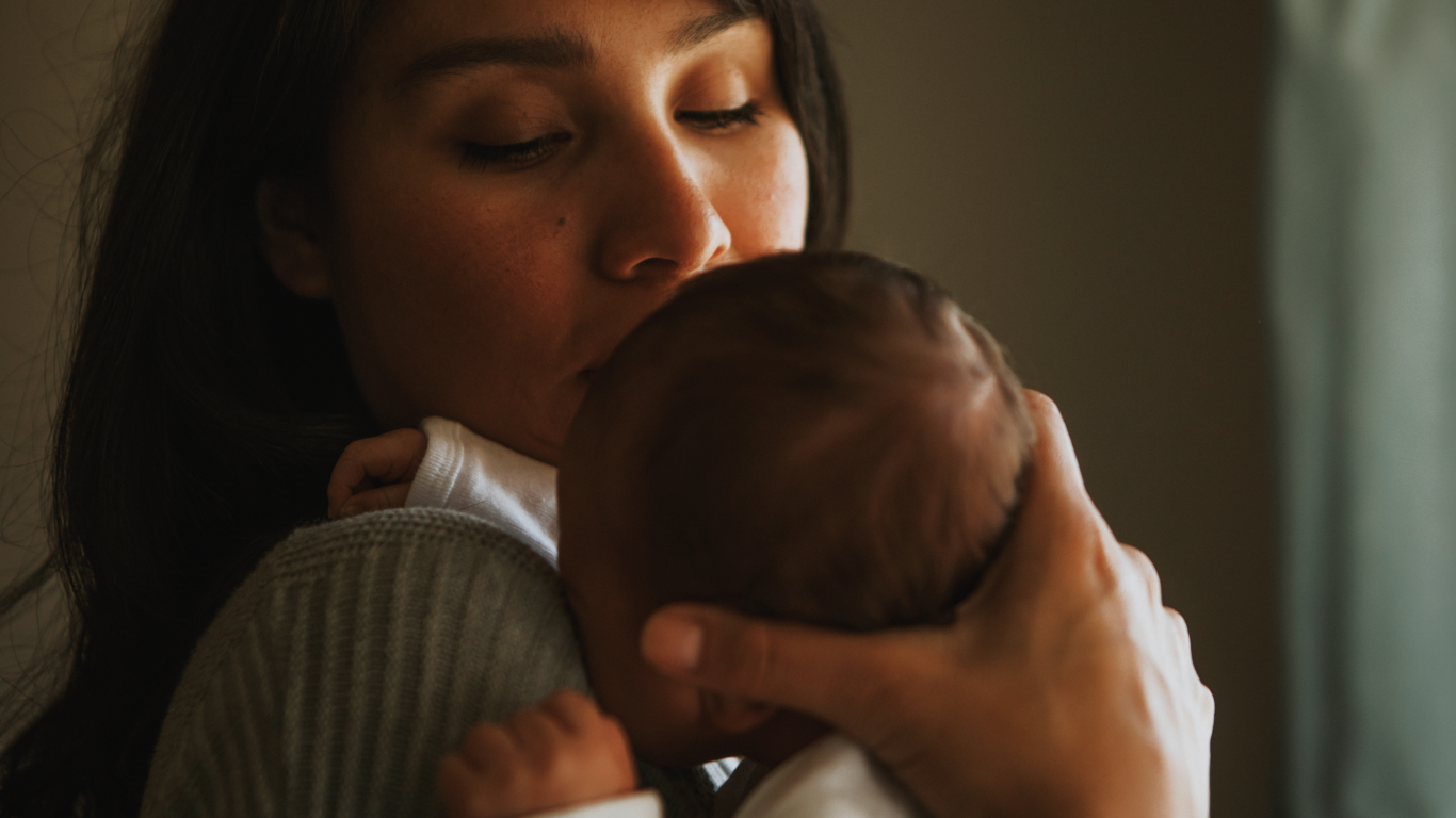 Mãe segurando bebê no colo, para falar sobre quando o bebê não sustenta a cabeça