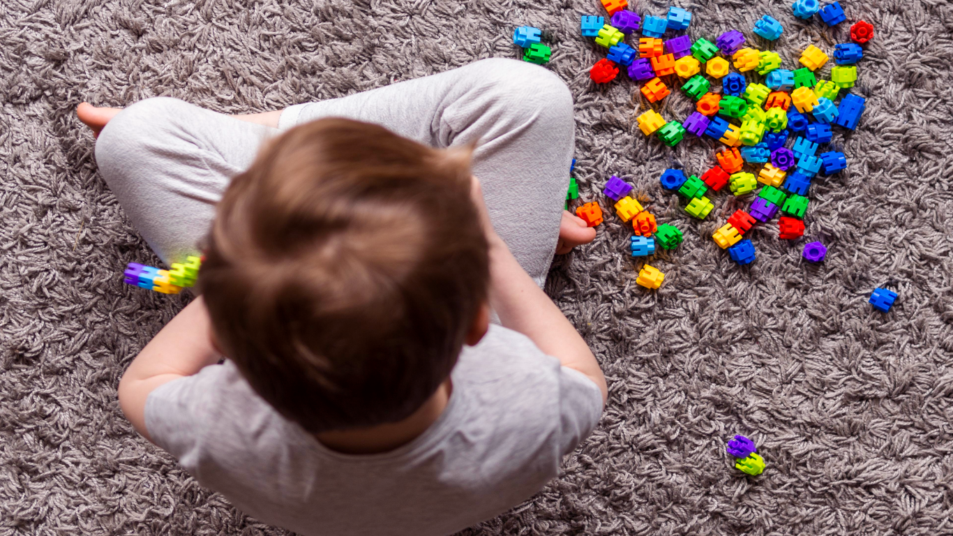 Menino com brinquedos coloridos, para falar sobre intervenção precoce no TEA